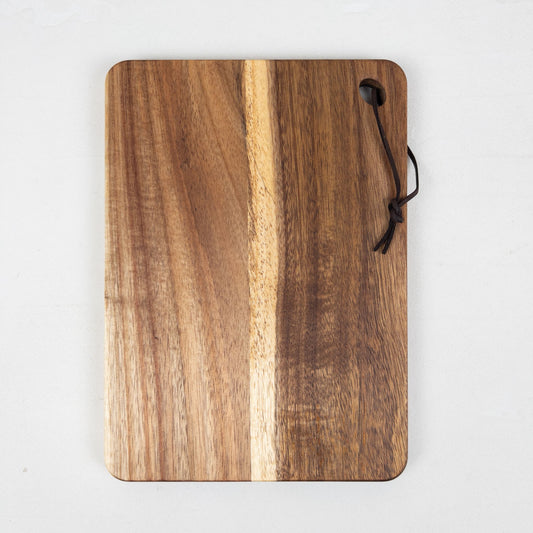 Acacia wooden breadboard with a handle on a white background