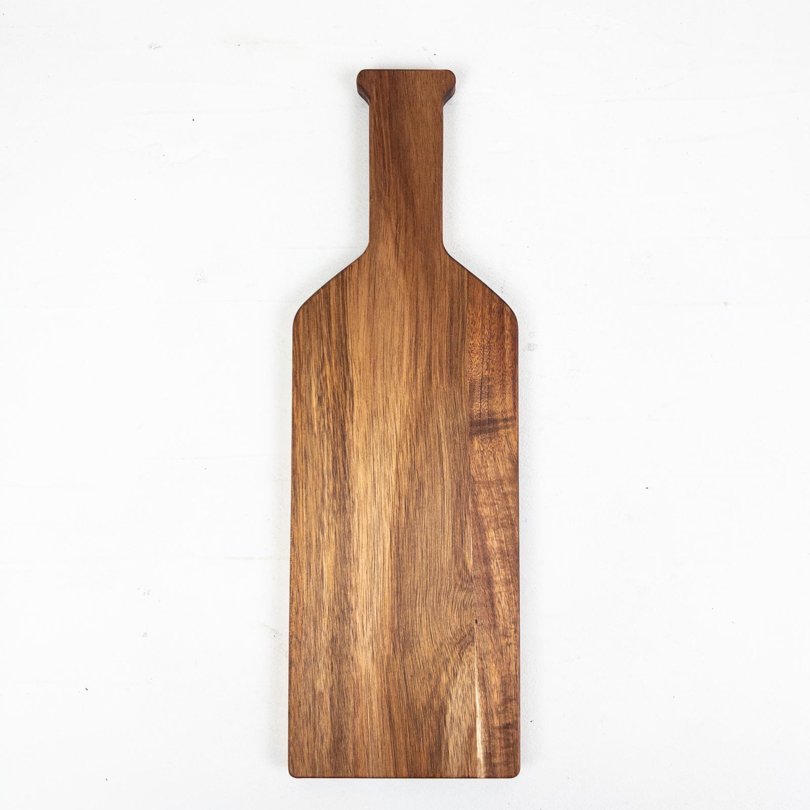 Bottle-shaped acacia wooden serving board on a white background